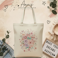 Square-ready cream canvas tote with feminine pastel floral and bow sublimation on an Anais Dream Creation branded background